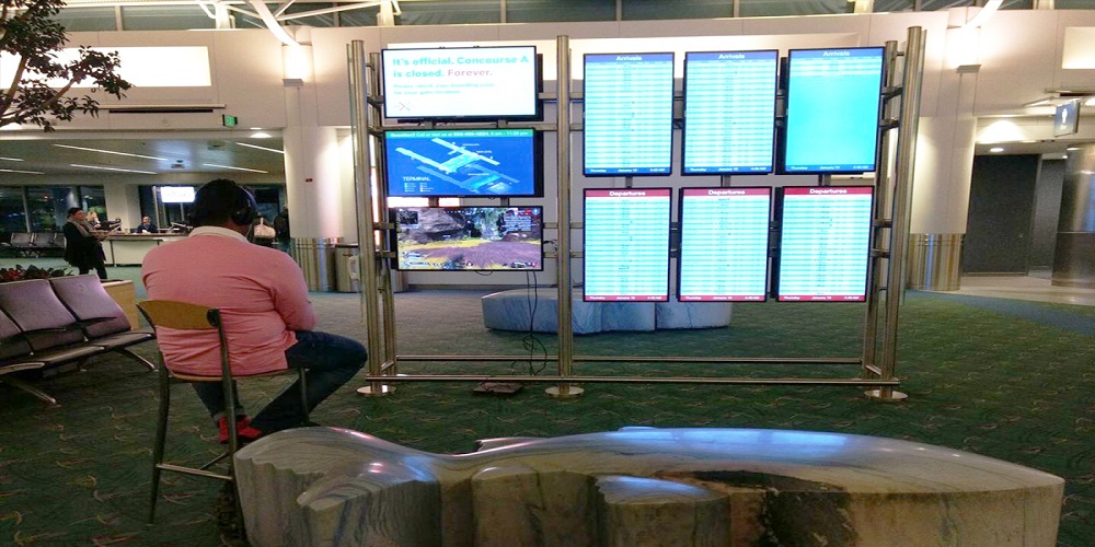man at airport plays video games