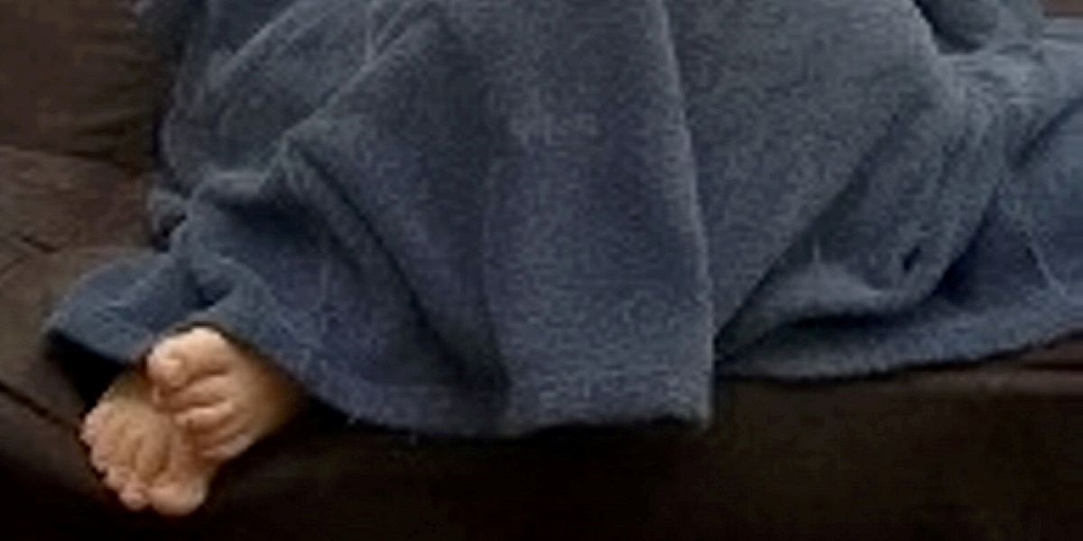 A wanted guy is discovered hiding under a blanket with his feet protruding