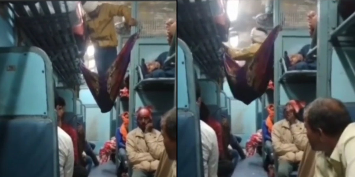 A man creates his own bed with a blanket in the train aisle