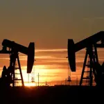 Oil prices slip but stay on track for monthly gain