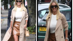 Christine McGuinness slaying in beige coat and brown miniskirt