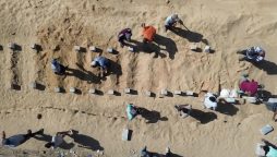 At mass burial in Gaza, Palestinians mourn the unknown dead.